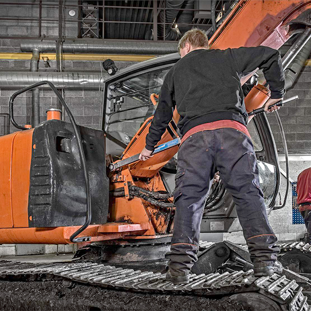 In the field engineer doing pin maintenance on machine